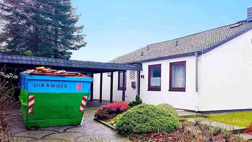Ditting Räumungen bei einer Hausauflösung in Holm – gefüllter Sperrmüllcontainer auf dem Grundstück nach der Entrümpelung